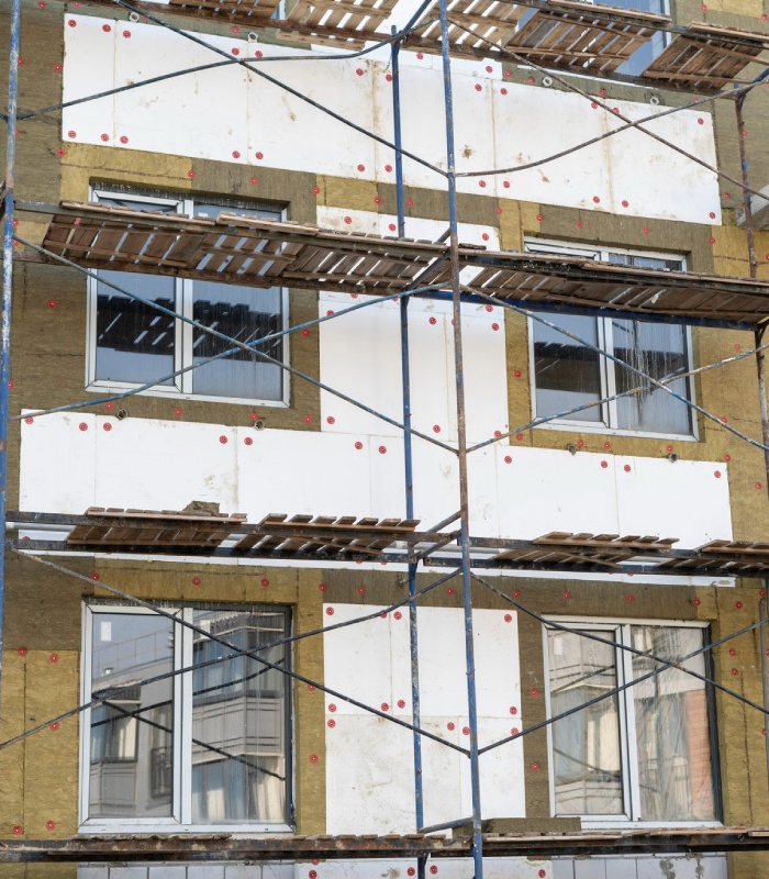 Ravalement de façade en cours avec pose d’isolant et panneaux fixés sur l’extérieur