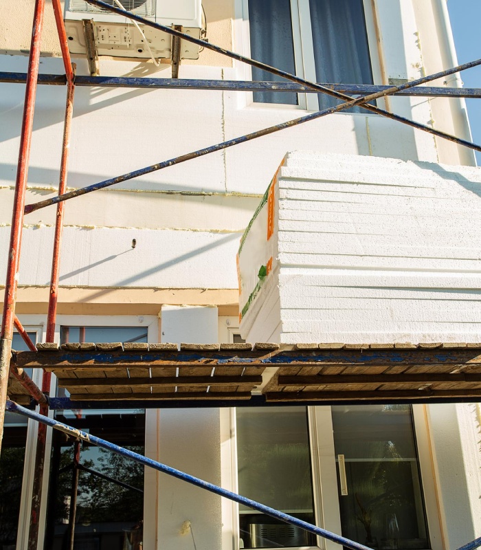 Rénovation de façade avec pose de panneaux isolants et échafaudage