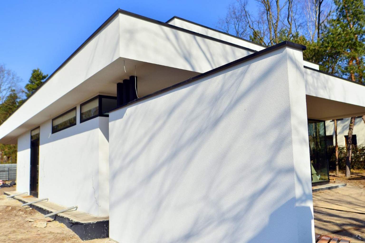 Artisan posant des panneaux isolants en façade dans le cadre d’une isolation thermique par l’extérieur pour améliorer la performance énergétique d’une maison.